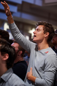 Student singing in chapel