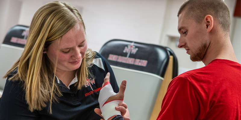 Athletic trainer assisting student