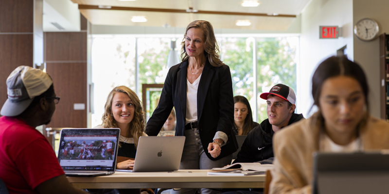 Vonda Post talking with students in the library