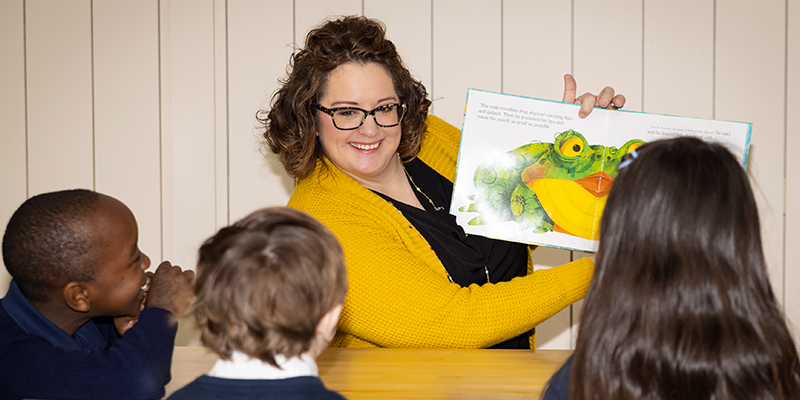 Becky Thompson, a 2022 Northwestern College M.Ed. graduate, reads to children at the Seven Hills Preparatory Academy in Bloomington, Minnesota.