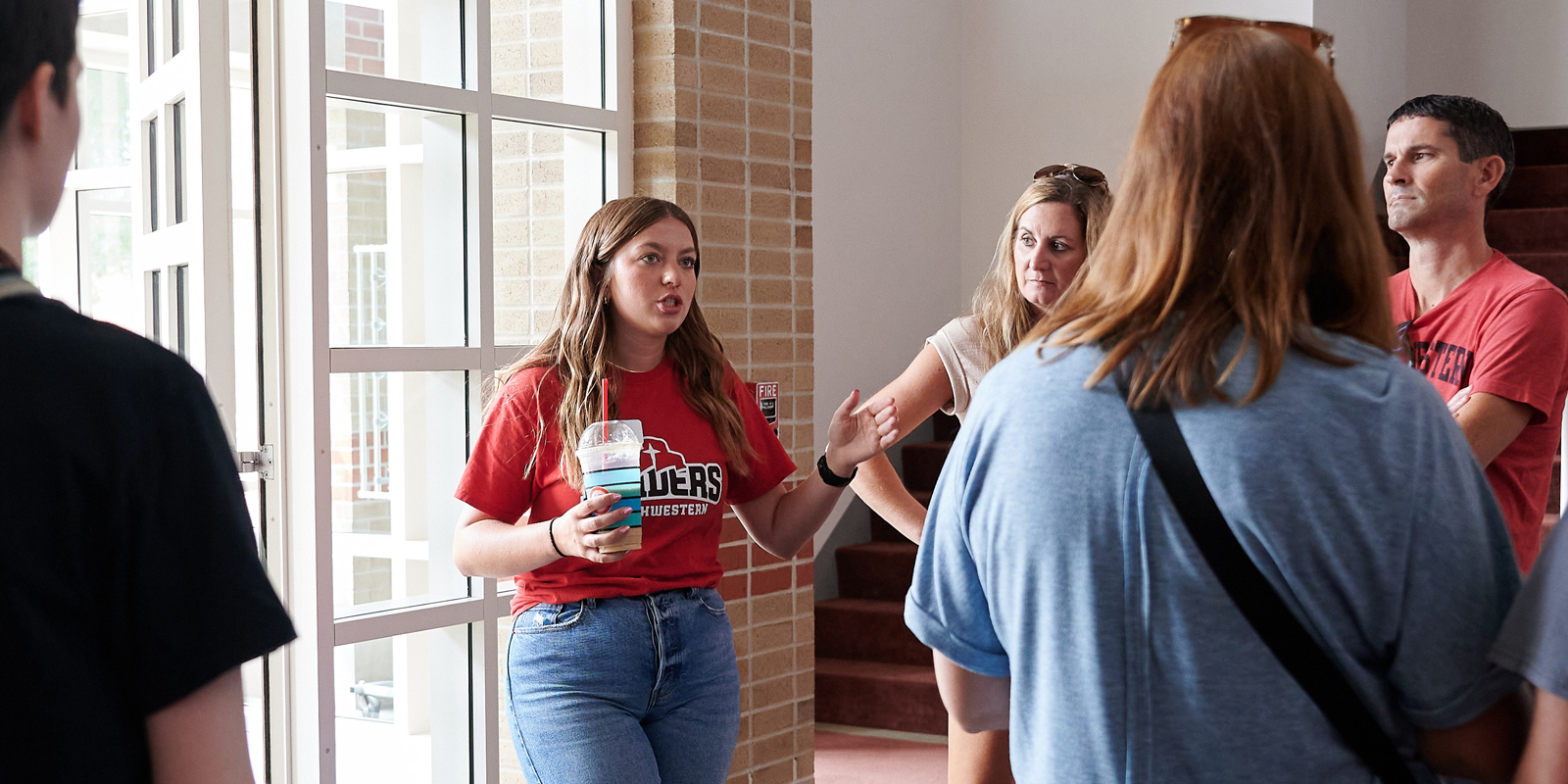 A student gives a campus tour to incoming freshmen and their parents