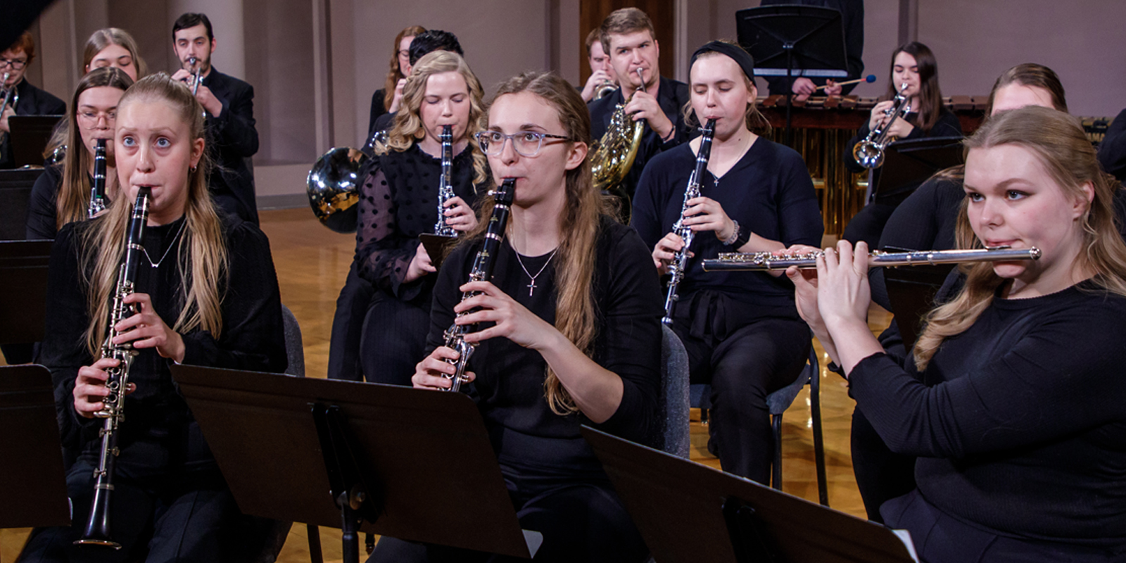 Clarinetists look at the conductor while performing during a concert