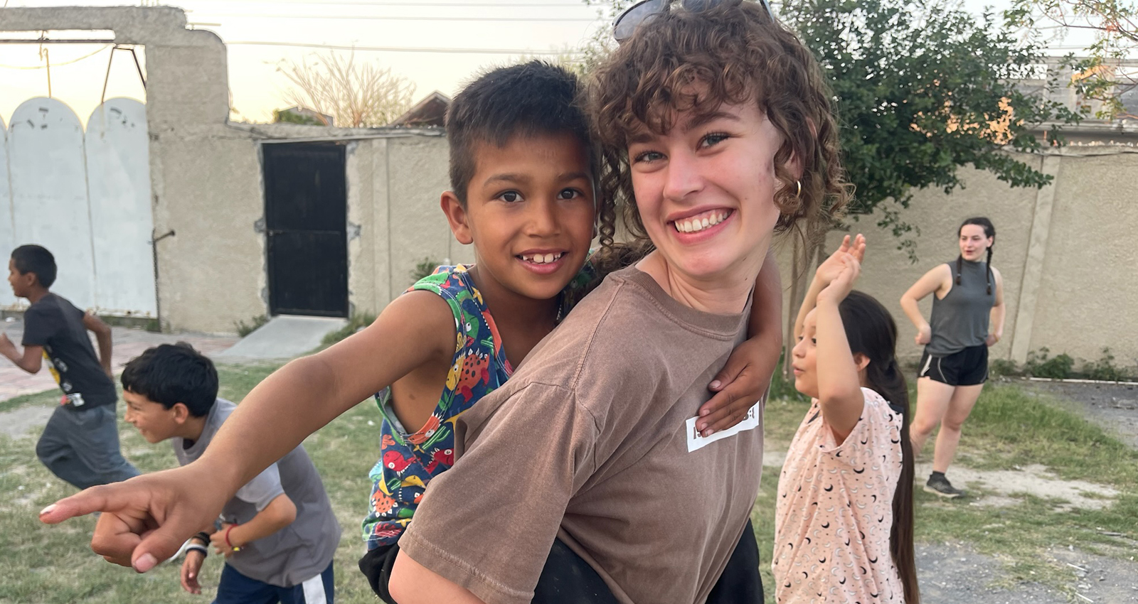 A female student carries a Latino child