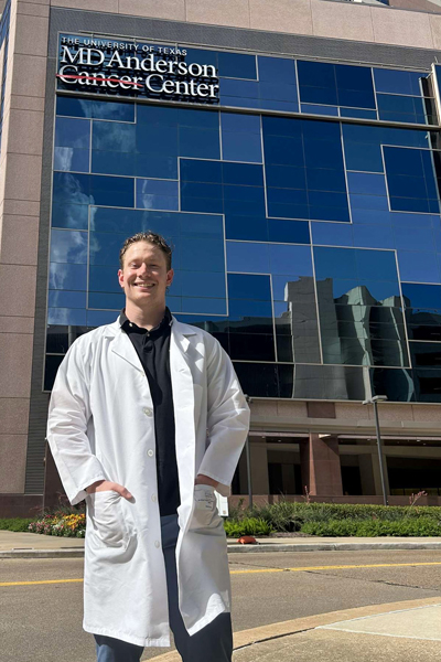 Dane Schoenborn standing in front of the MD Anderson Cancer Center.